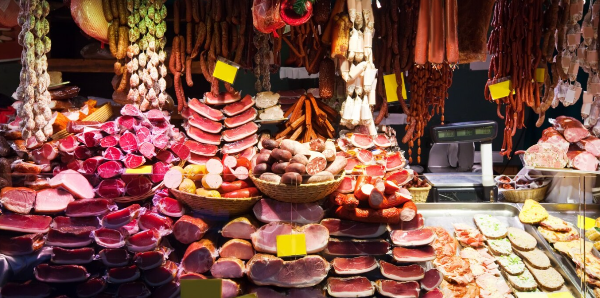 Assorted cured meats and sausages displayed vibrantly at a deli counter